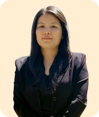 Woman with long black hair wearing black jacket looking forward on light peach background